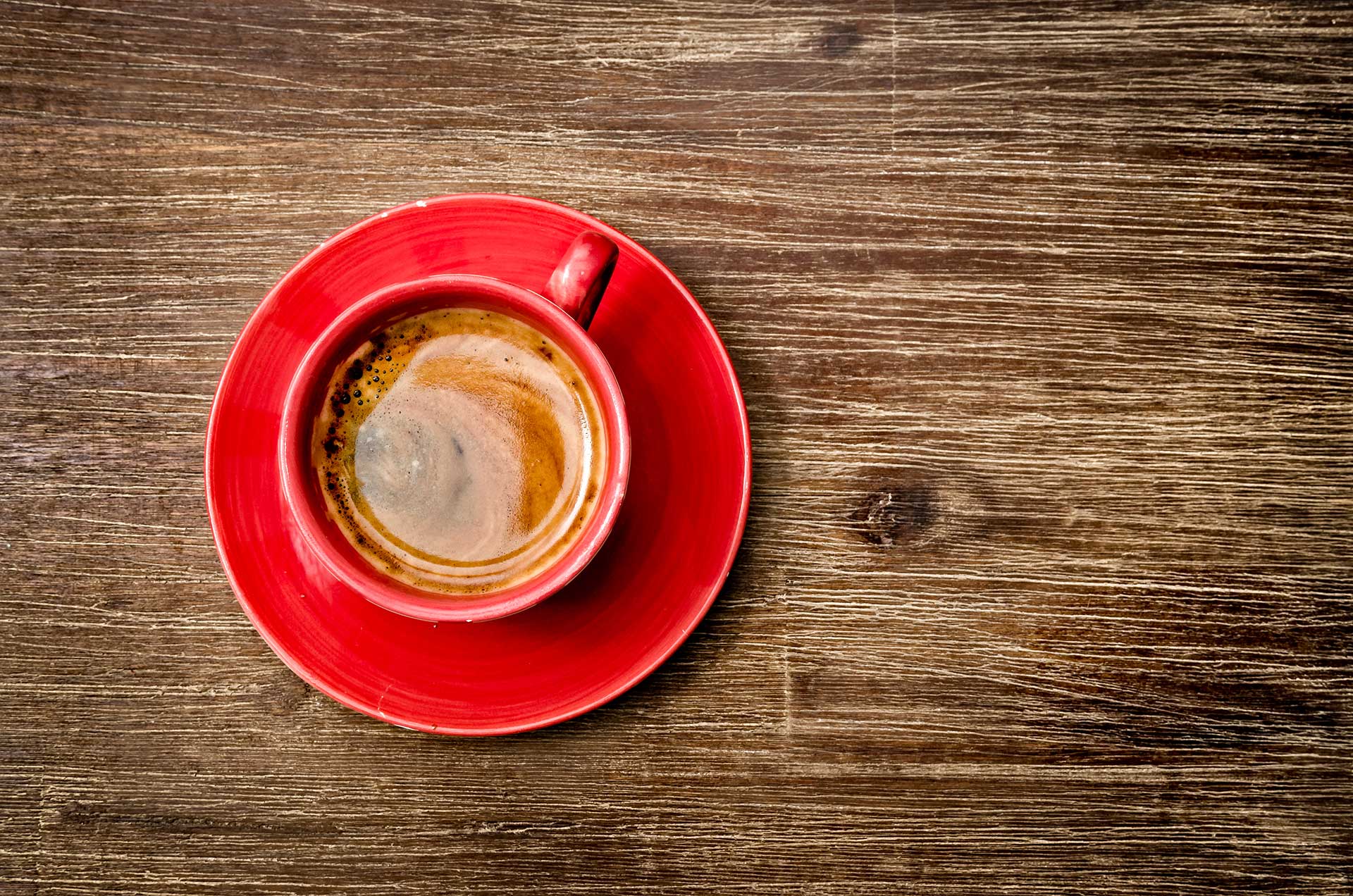4155d5bb-a4af-420e-81a1-e3e2ea9f88eb Photo of a cup of coffee on a wood tabel shot from above